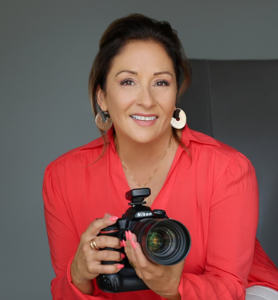 Jojo Amicone, owner and lead photographer of SoFlo Living Media, holding a professional camera